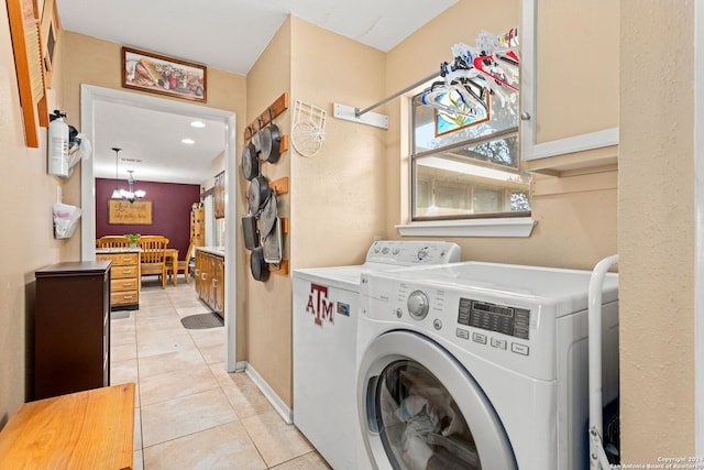 laundry area featuring cabinets, washer and dryer, an inviting chandelier, and light tile patterned floors