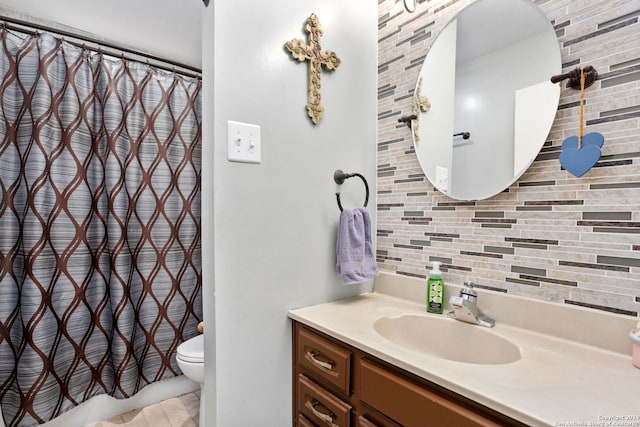 bathroom with vanity, decorative backsplash, toilet, and walk in shower