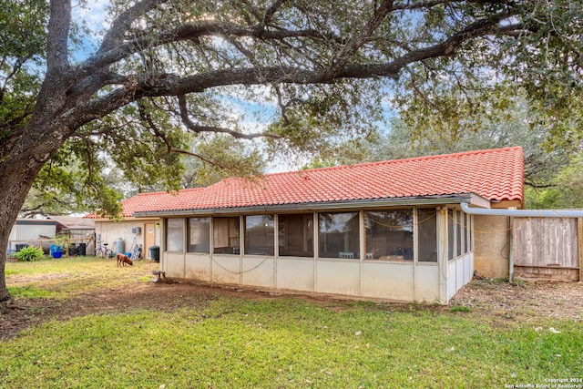 back of house with a lawn and a sunroom