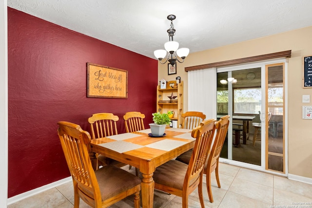 dining space with light tile patterned flooring and a chandelier