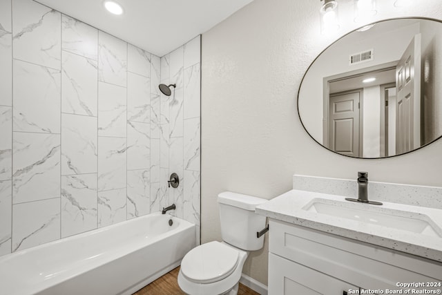 full bathroom featuring toilet, vanity, and tiled shower / bath