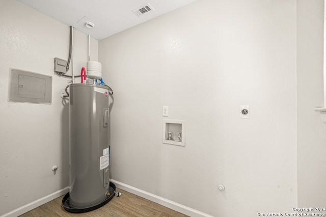 utility room featuring electric panel and electric water heater