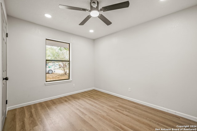 empty room with ceiling fan and light hardwood / wood-style flooring