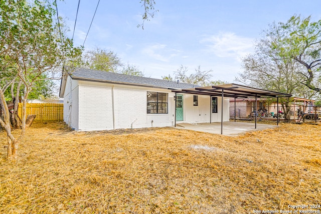 back of property featuring a lawn and a patio area