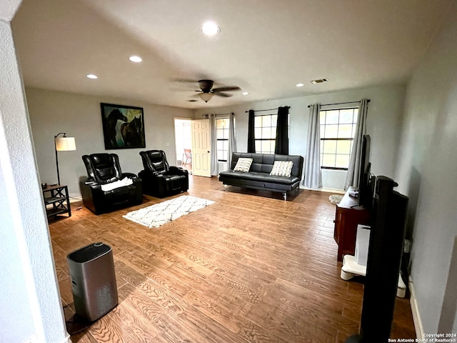 living room featuring wood-type flooring and ceiling fan