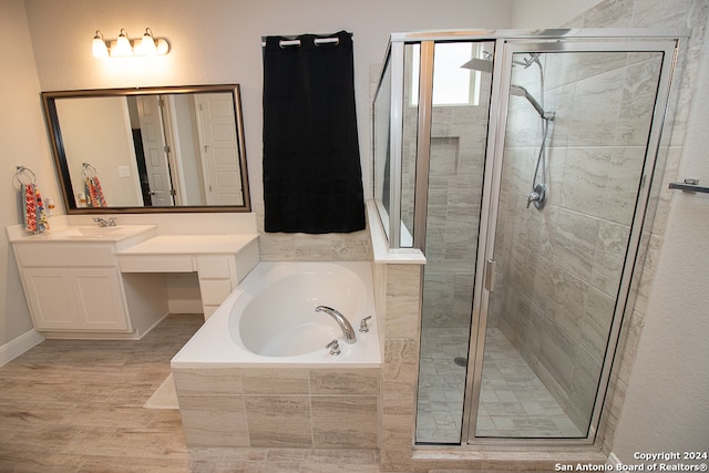 bathroom with vanity, independent shower and bath, and wood-type flooring