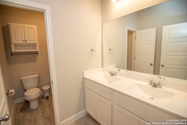 bathroom with hardwood / wood-style floors, vanity, and toilet