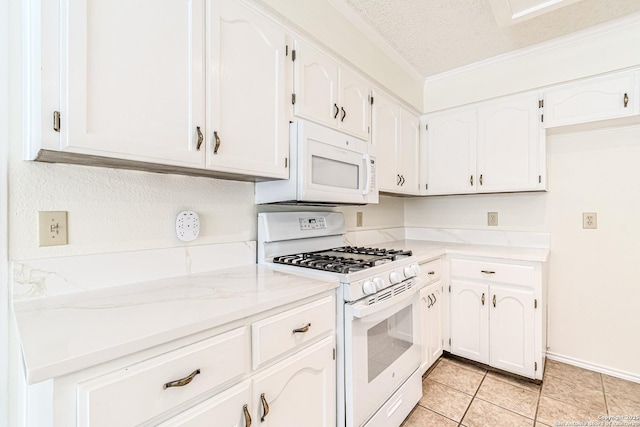 kitchen with a textured ceiling, white cabinetry, white appliances, light tile patterned floors, and light stone countertops