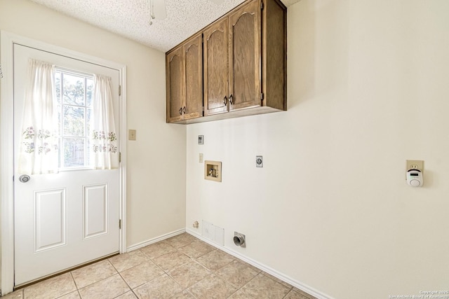 laundry room with cabinets, hookup for an electric dryer, hookup for a washing machine, light tile patterned floors, and a textured ceiling