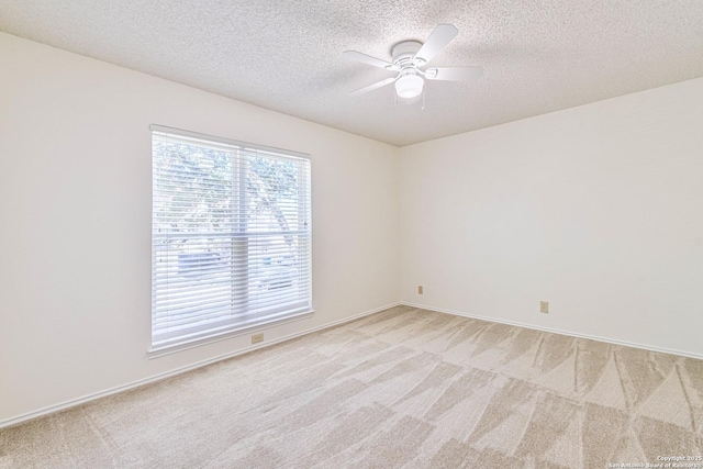 carpeted empty room featuring a textured ceiling and ceiling fan