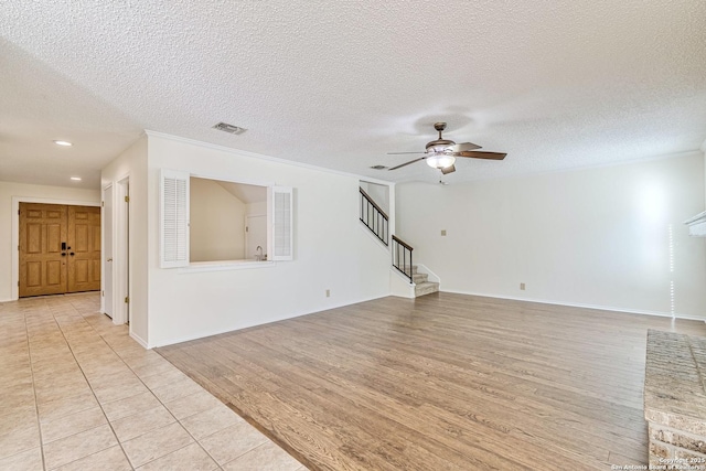 tiled spare room with a textured ceiling, ceiling fan, and crown molding