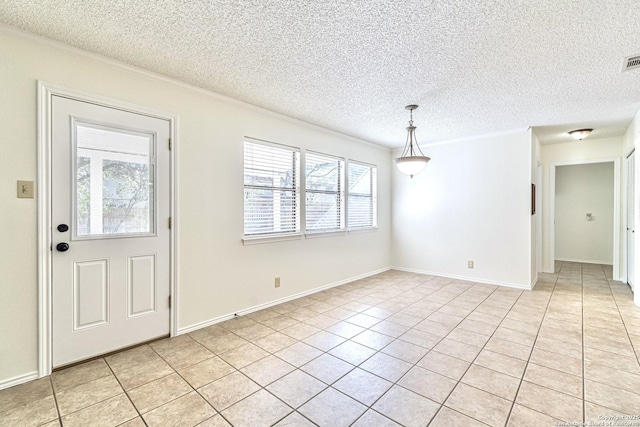 tiled foyer entrance featuring a textured ceiling and crown molding