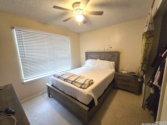 bedroom with multiple windows, a textured ceiling, and ceiling fan