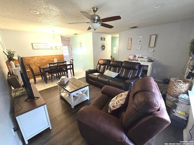 living room with wood-type flooring, a textured ceiling, and ceiling fan with notable chandelier