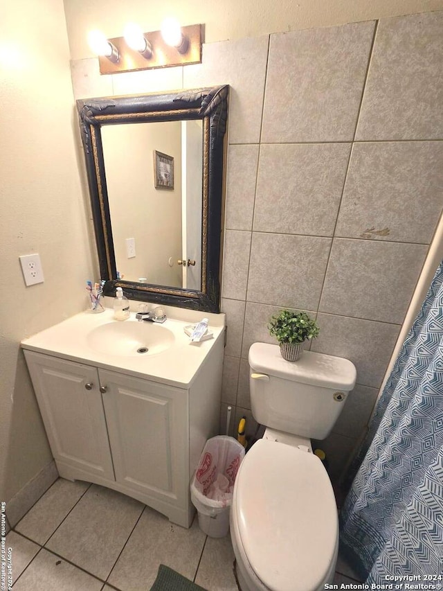 bathroom with toilet, tile patterned flooring, a shower with curtain, vanity, and tile walls