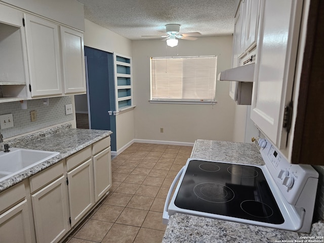 kitchen with white cabinets, light tile patterned floors, backsplash, a textured ceiling, and white stove