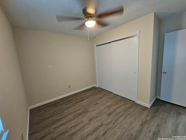 unfurnished bedroom with a closet, ceiling fan, a textured ceiling, and dark hardwood / wood-style flooring