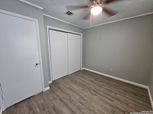 unfurnished bedroom featuring hardwood / wood-style floors, ceiling fan, a textured ceiling, a closet, and crown molding