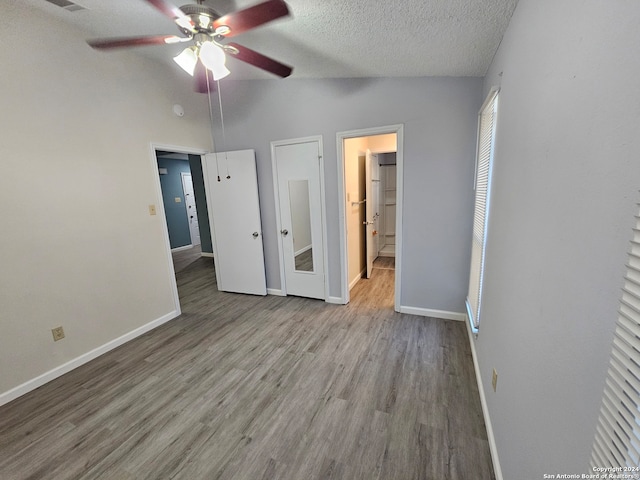 unfurnished bedroom featuring high vaulted ceiling, a textured ceiling, light wood-type flooring, and ceiling fan