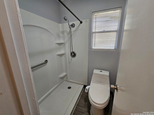 bathroom with toilet, a shower, and wood-type flooring