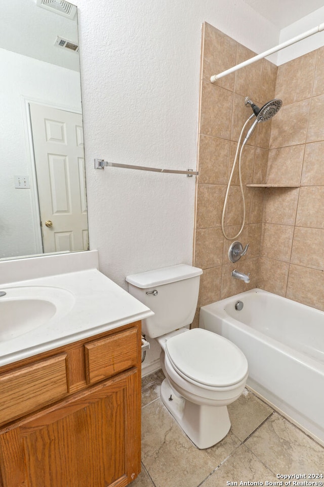 full bathroom featuring toilet, tiled shower / bath combo, vanity, and tile patterned floors