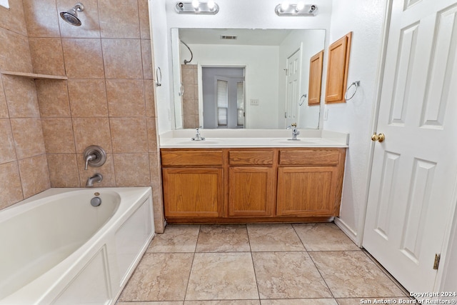 bathroom featuring vanity and tiled shower / bath