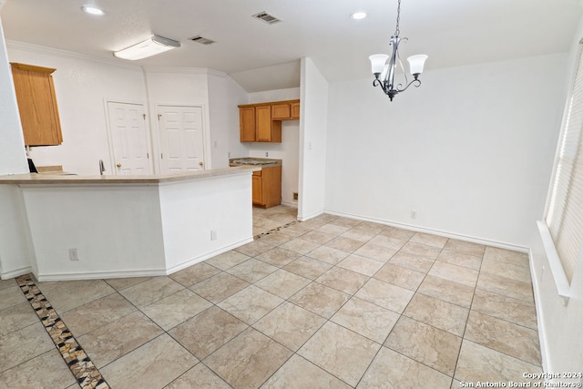 kitchen with crown molding, kitchen peninsula, decorative light fixtures, and an inviting chandelier