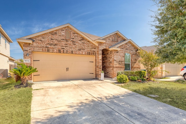 view of front of house with central AC, a garage, and a front lawn