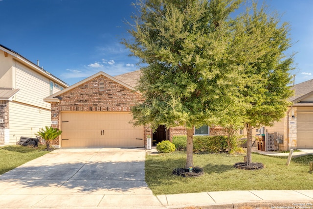 view of property hidden behind natural elements featuring a front yard and a garage