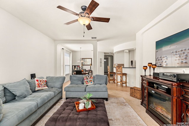 living room featuring ceiling fan with notable chandelier