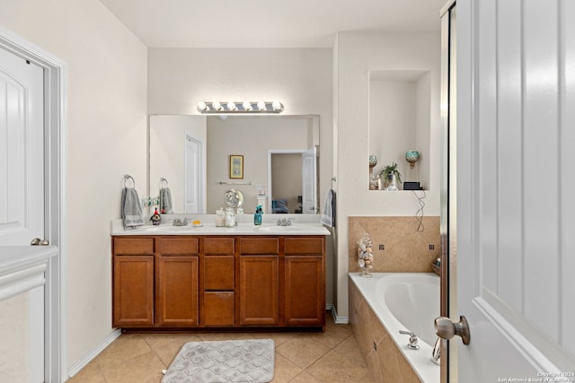 bathroom featuring vanity, tiled tub, and tile patterned flooring