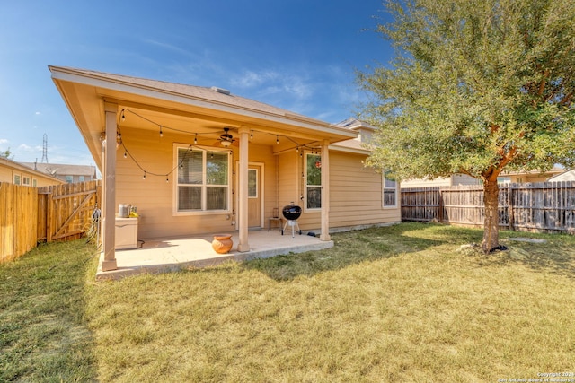 rear view of property with a yard, ceiling fan, and a patio area