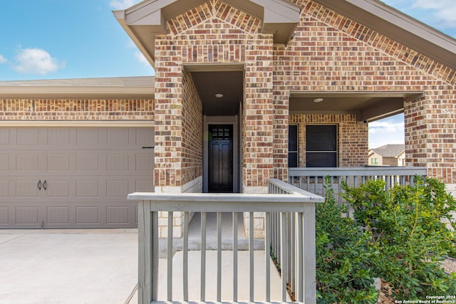 entrance to property with covered porch and a garage