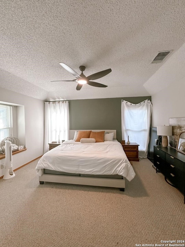 bedroom with a textured ceiling, carpet floors, and ceiling fan