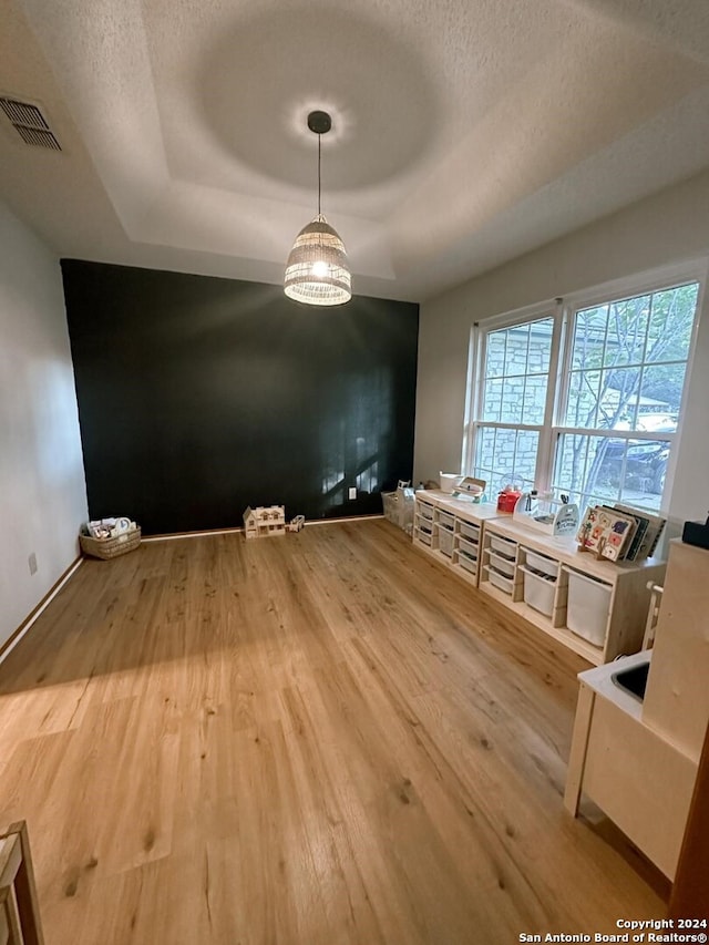 unfurnished dining area with a textured ceiling and hardwood / wood-style flooring