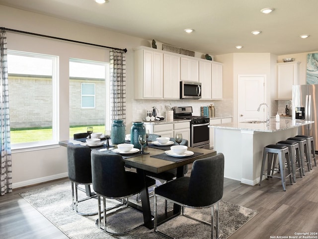 dining area with light wood-type flooring, baseboards, and recessed lighting