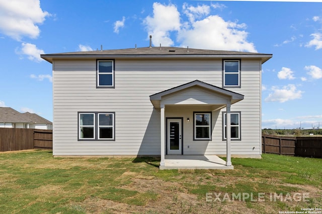 back of property with a yard and a patio area