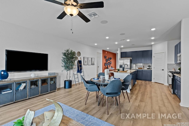 dining space featuring ceiling fan, sink, and light hardwood / wood-style flooring