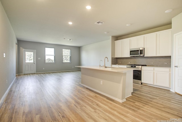 16547 Rosemary Rdg, San Antonio, TX 78112 - kitchen featuring light wood-style floors, visible vents, tasteful backsplash, and appliances with stainless steel finishes