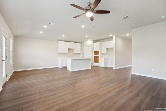 unfurnished living room with ceiling fan and wood-type flooring