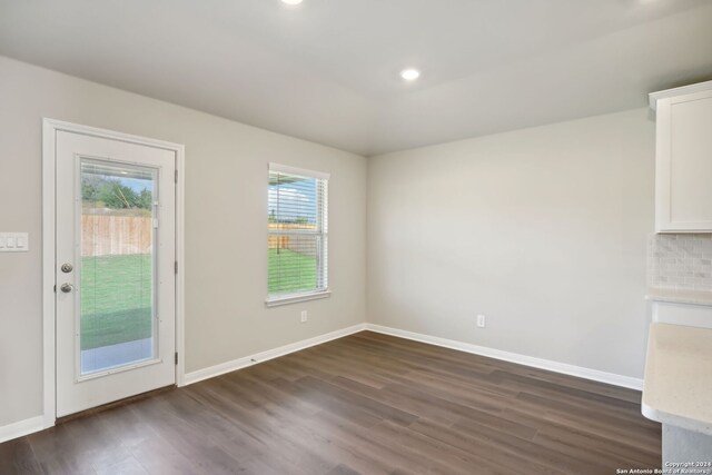 unfurnished dining area with dark hardwood / wood-style flooring and a wealth of natural light