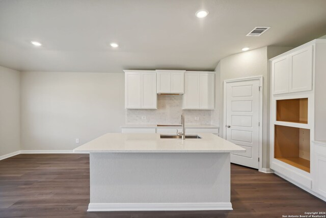 kitchen with white cabinetry, a center island with sink, and dark hardwood / wood-style floors