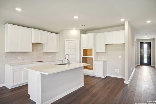 kitchen featuring dark hardwood / wood-style floors, white cabinetry, and an island with sink