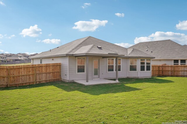 rear view of property featuring a patio area and a yard