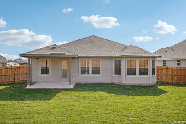 rear view of house featuring a yard and a patio