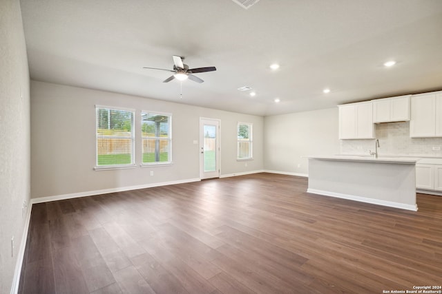 unfurnished living room with ceiling fan and dark hardwood / wood-style floors