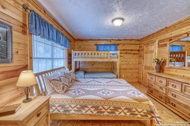 bedroom featuring a textured ceiling and wooden walls