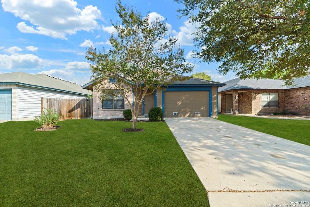 single story home featuring a garage and a front yard