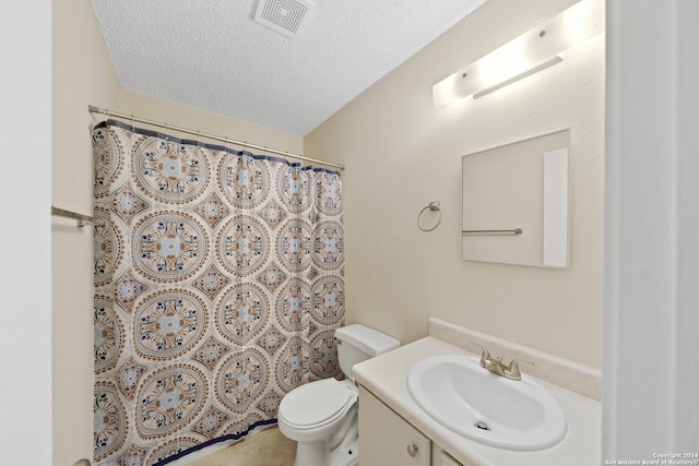 bathroom featuring curtained shower, vanity, a textured ceiling, and toilet