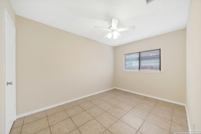 tiled spare room featuring a textured ceiling and ceiling fan